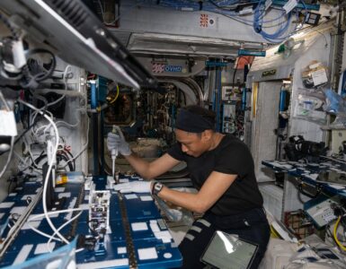NASA astronaut Jeanette Epps uses a pipette to analyze bacteria samples aboard the International Space Station