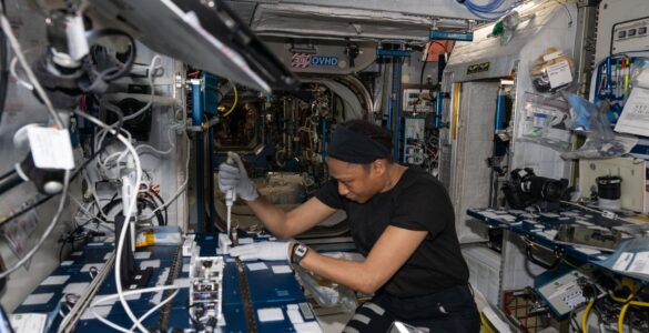 NASA astronaut Jeanette Epps uses a pipette to analyze bacteria samples aboard the International Space Station