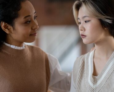 Two women having a supportive conversation in a classroom setting