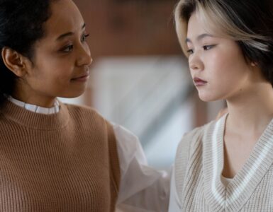 Two women having a supportive conversation in a classroom setting