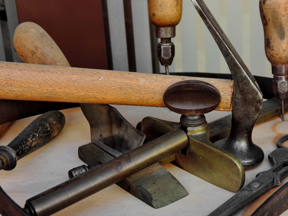 Metal hand tools with wooden handles arranged on a workbench