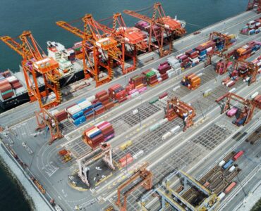 Aerial view of a cargo ship, cranes, and containers at the Port of Vancouver