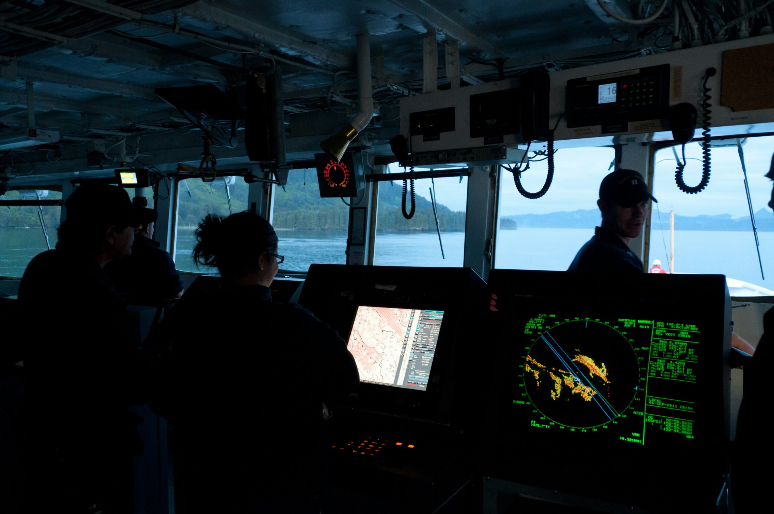 A researcher working at a computer aboard a vessel in rough coastal waters
