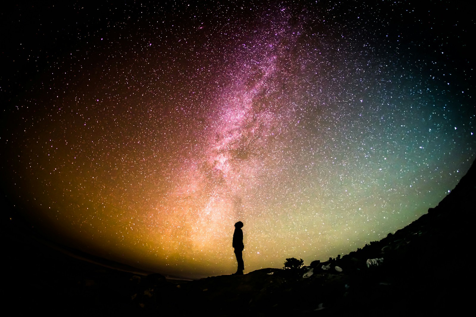 A person looking up at a dense field of stars in a dark night sky