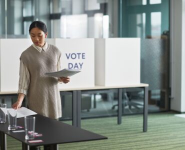 Poll worker organizing voting materials before voters arrive