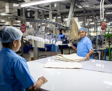 Workers organizing fabric on a textile factory production line