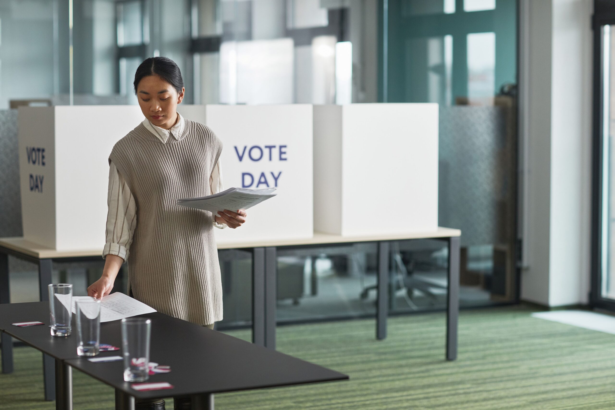 A poll worker organizing voting materials before a polling place opens