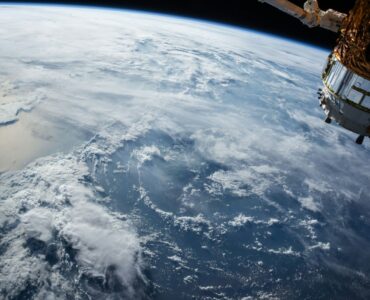 A satellite orbiting above Earth, where operators track debris and plan collision avoidance maneuvers.