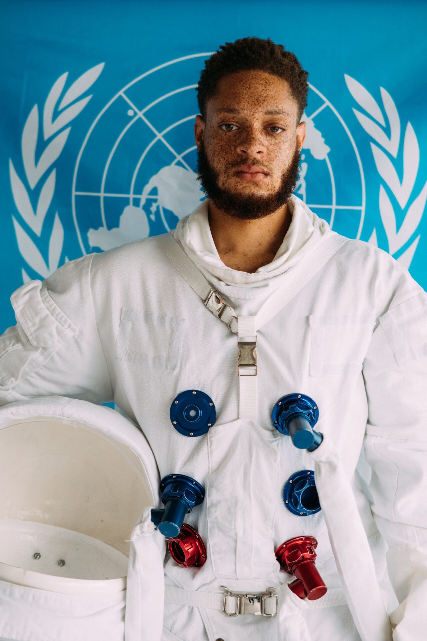 Person standing in a white spacesuit with a reflective helmet