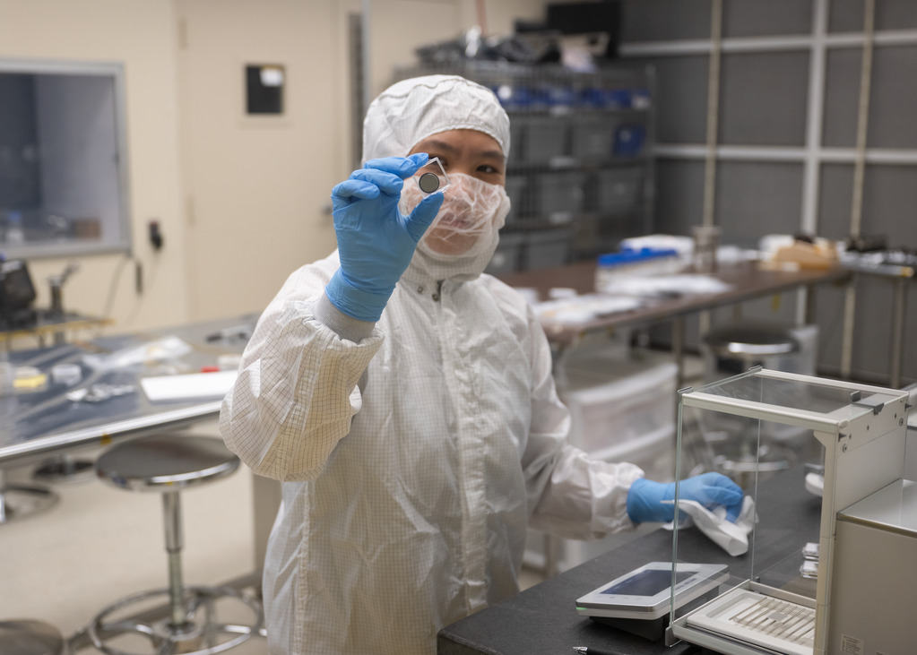 A NASA technician weighs a small SPEARS battery after thermal-vacuum testing.