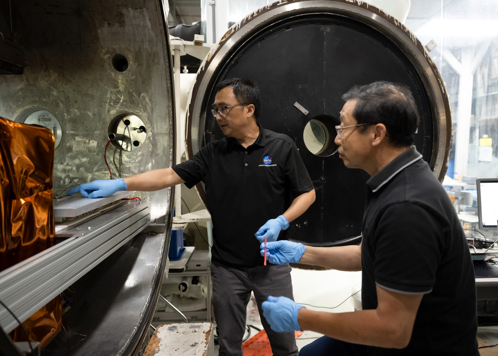 NASA researchers Yi Lin and Ji Su remove SPEARS battery cells from a thermal-vacuum chamber.