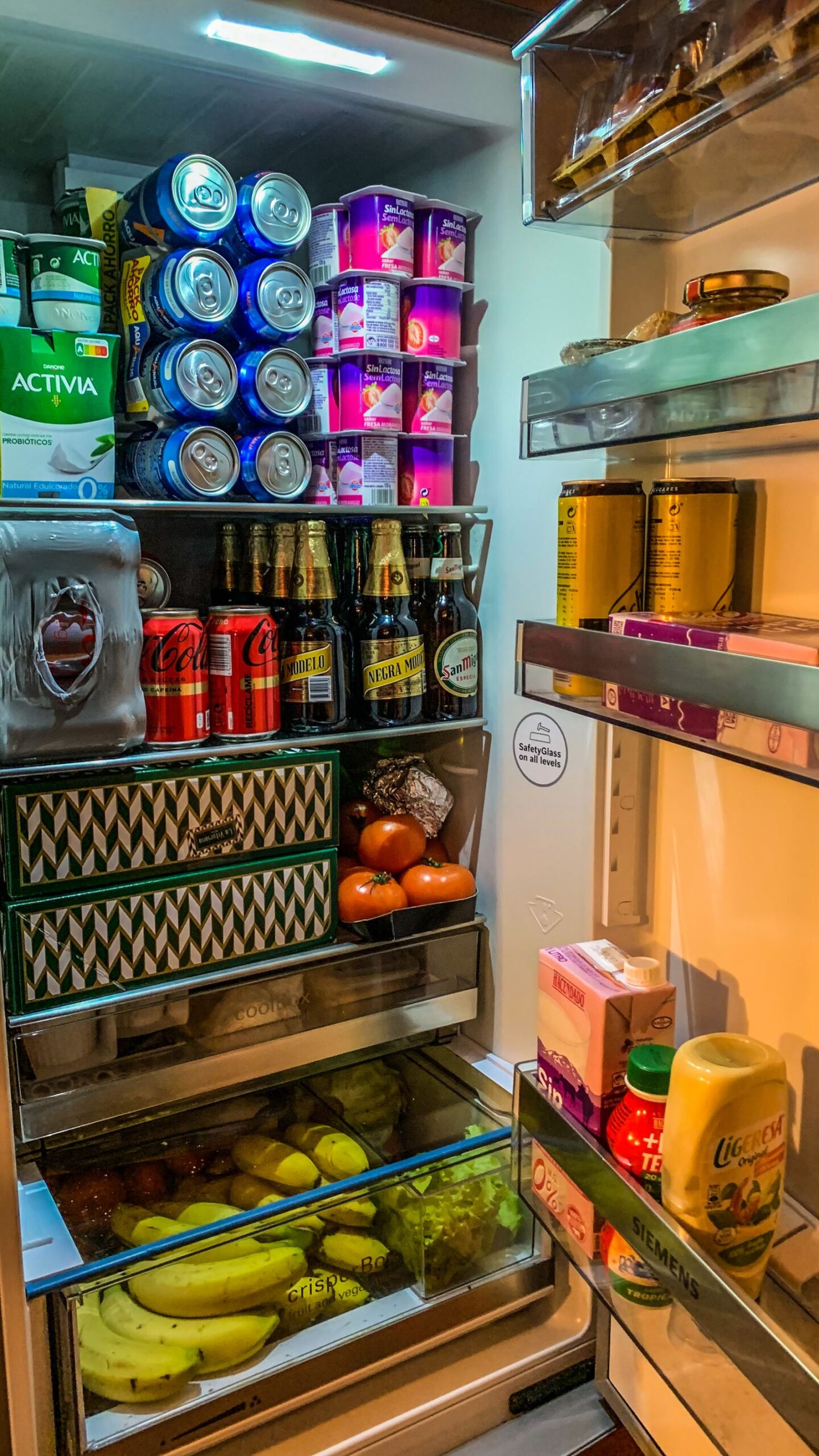 Open refrigerator stocked with drinks, produce, and dairy foods