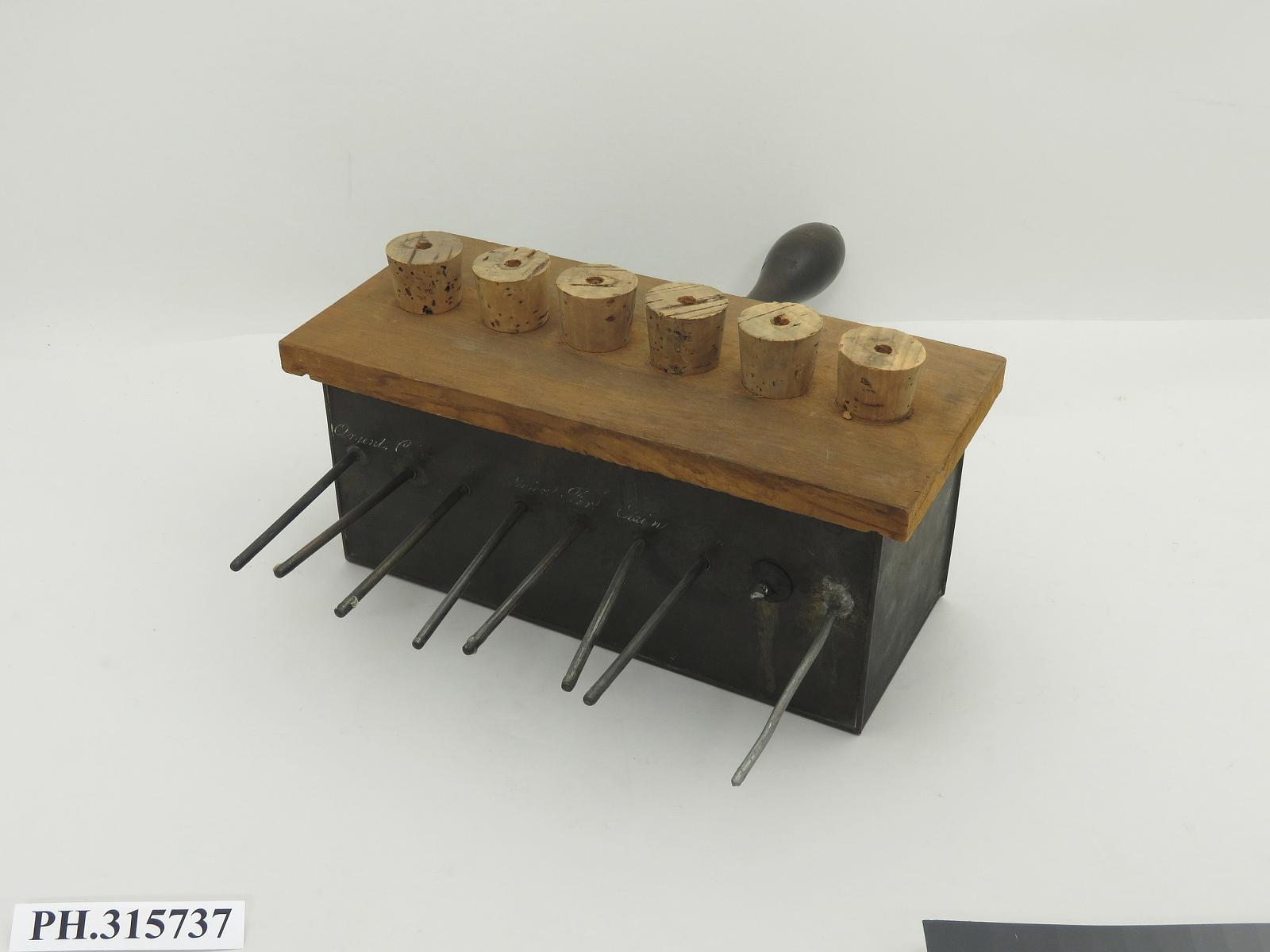 Historic classroom apparatus with metal rods mounted through a wooden block