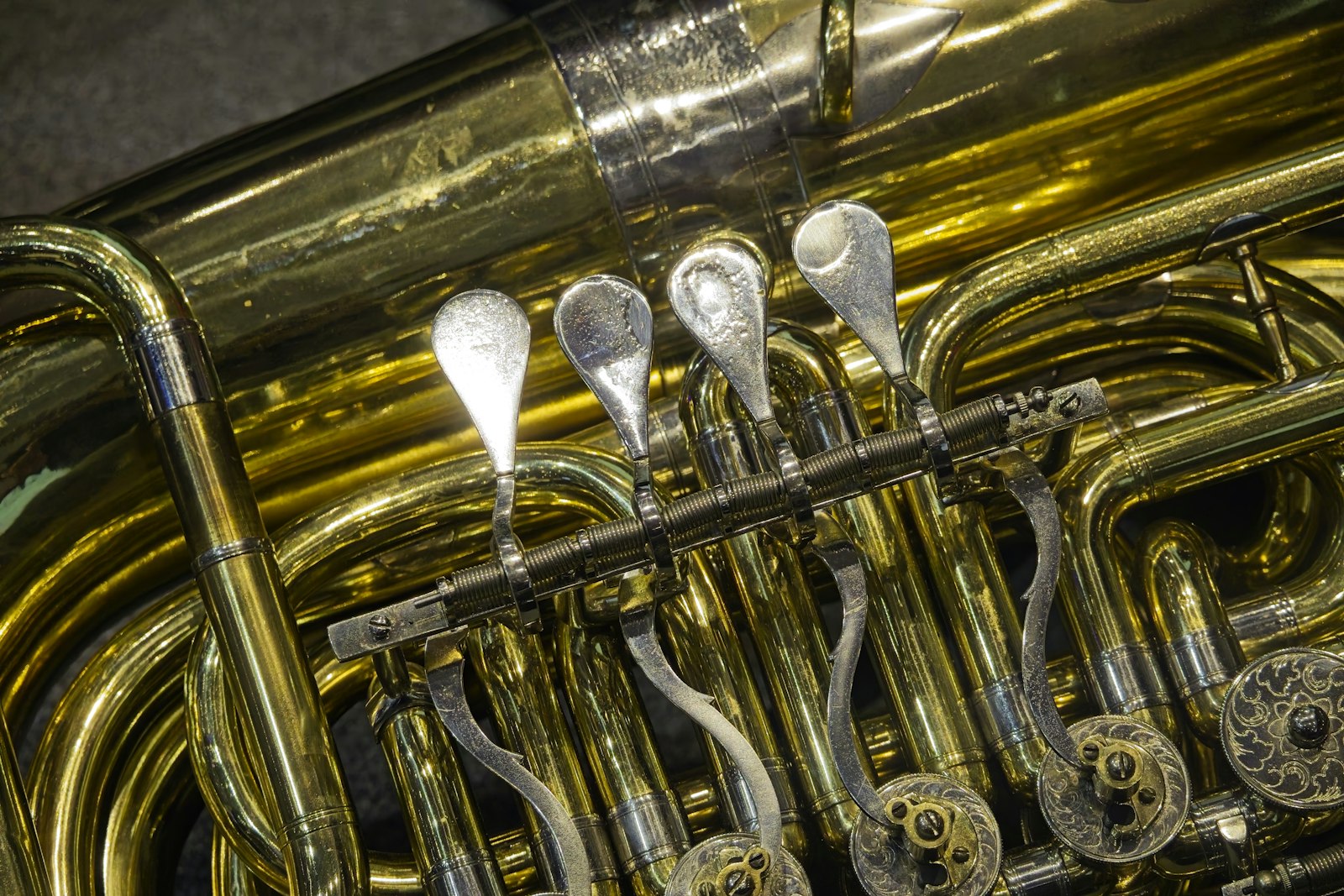 Close-up of tuba valves surrounded by long curved brass tubing